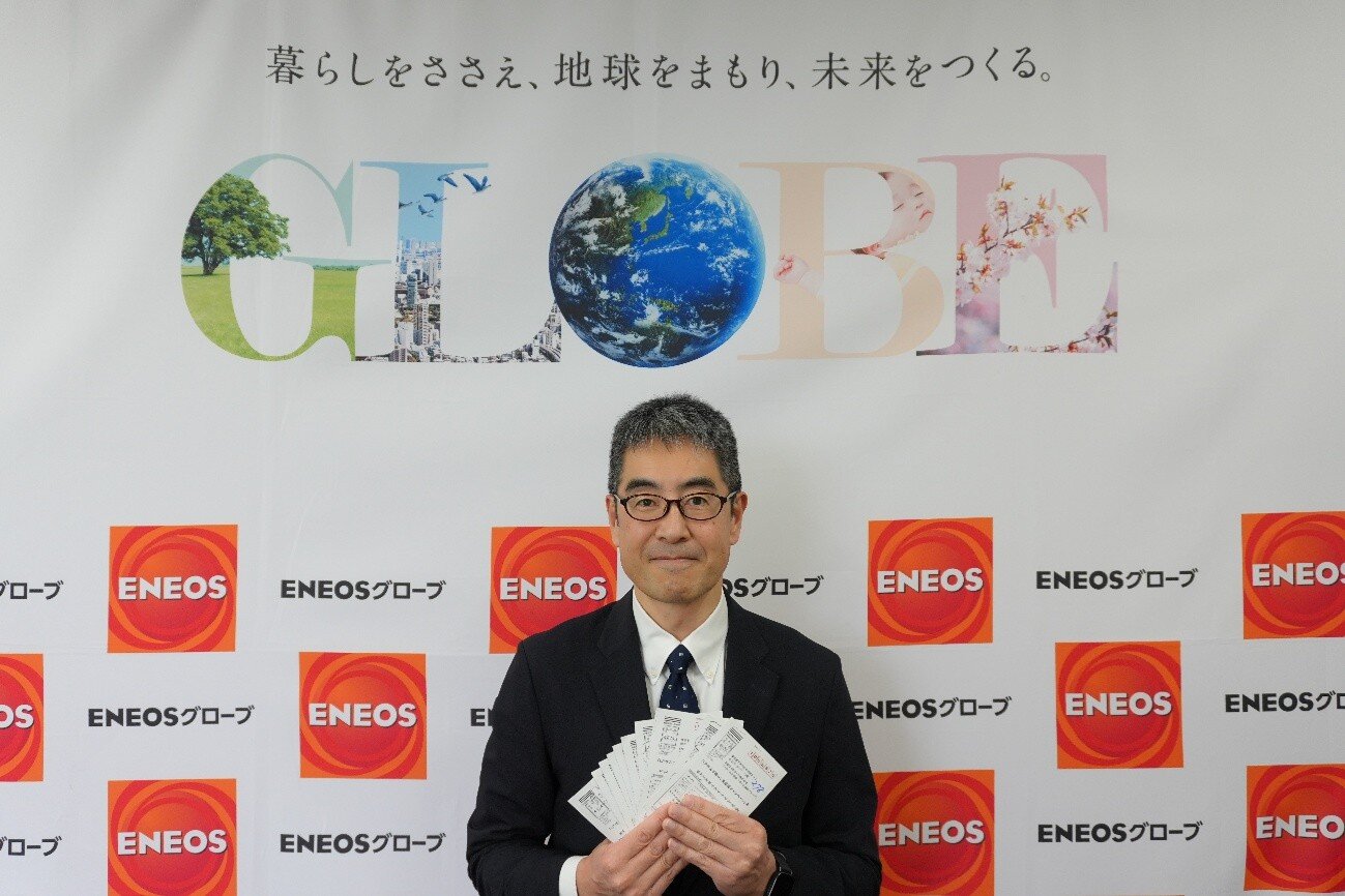 当選者の応募はがきを持つ島村部長